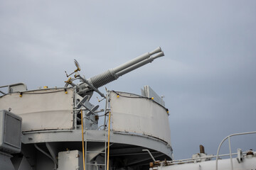 A double-barreled anti-aircraft gun on a historic warship. Photo taken on a cloudy day, soft light