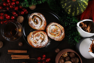 Puff rolls with raisins and chocolate cream in a black plate on the Christmas table, New Year. close-up