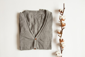 Men's gray stylish jacket with buttons and a branch of dry cotton on a white background, stylish