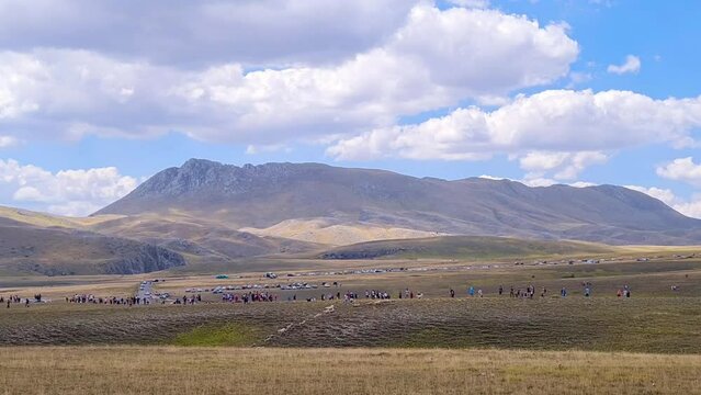 High angle of a flock of sheep running to pasture at  "Gransasso" at "Campo Imperatore" sheep show