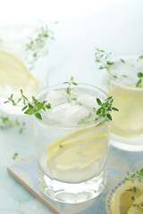 Fototapeta na wymiar Glasses with lemon and thyme refreshing drink
