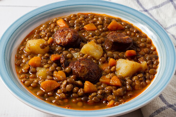 Close-up of a traditional lentil soup with legs, carrots and chorizo. Mediterranean cuisine