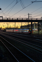 Fototapeta na wymiar illuminated moving train and train tracks at sunset