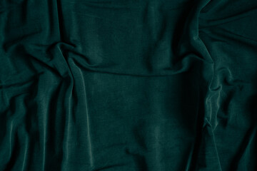 Green crumpled fabric as a background close-up, synthetic fabric