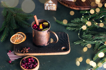 Christmas mulled wine or gluhwein with spices and orange slices on rustic table, traditional drink on winter holiday, magic light, selective focus
