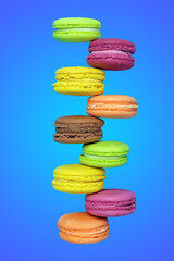 Sweet and colorful French macaroons on blue background, French biscuit delicacy, festive almond cookie design