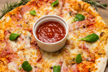 Freshly baked pizza with ham, tomato, and cheese