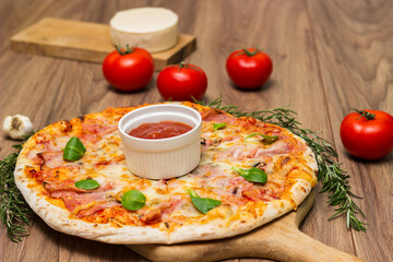 Freshly baked pizza with ham, tomato, and cheese