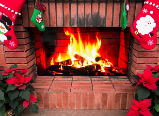 A fake fireplace is a Christmas decoration. Christmas socks, poinsettia. And the burning fire on...