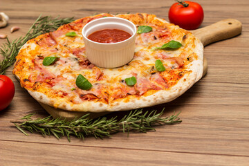 Freshly baked pizza with ham, tomato, and cheese