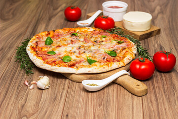 Freshly baked pizza with ham, tomato, and cheese