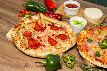 Pepperoni pizza and pizza Capricciosa with mozzarella cheese, ham, tomato sauce, salami, mushroom, pepper, spices and fresh basil