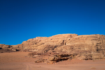 Fototapeta na wymiar Wadi Rum, Jordan. A beautiful vibrant blue and orange view, Arabian desert, a dystopian martian landscape with unique rock formations and dunes. Backdrop for graphic resource or copy space no people