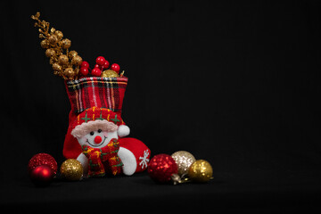 new year snowman and christmas sock with toys on black background