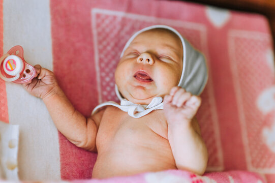A beautiful newborn baby, a little girl lies, sleeps in bed on a blanket. Photography, childhood.