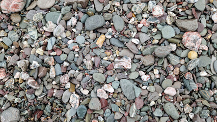 Glistening pebbles on the beach facing the ocean in November after rain