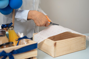 Crop unrecognizable person decorating wooden box