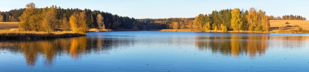 autumn view of pond and colorful autumnal forest