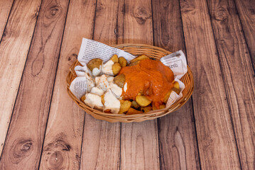 typical Madrid tapa of patatas bravas with sauce in a wicker basket
