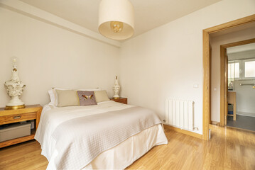 Bedroom with a double bed and huge porcelain lamp bases on top of the wooden bedside tables