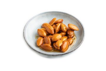 Almonds with honey isolated on white. side view, close up.