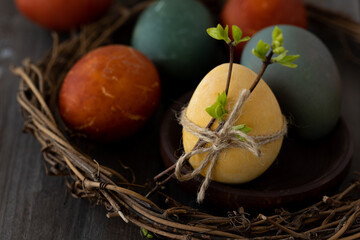 Easter eggs coloured with natural organic colorants: red cabbage, curcuma, onion peel. Handmade home decor, natural elements, eco-friendly, zero waste. Dark wooden background