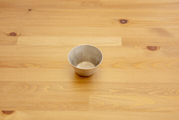 A table made of varnished pine wood and an empty aluminum container
