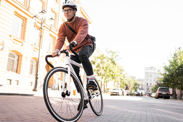 A man on a bicycle in a helmet goes to work urban eco transport