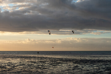 Fototapeta na wymiar Kitesurfen bei Sonnenuntergang am Brouwersdam in Zeeland