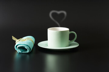 Mint-colored tea pair on a shiny black surface. Napkin lies nearby.  Copy space.