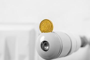 European coin on the thermostat of a hot central heating radiator