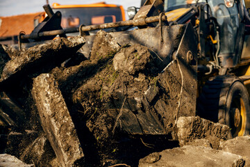 Fototapeta premium Close up of excavator removing asphalt from construction site.