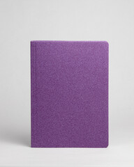  Purple diary in standing view on table on white background. Frontside