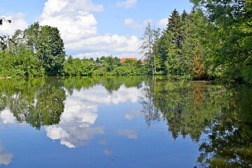 Obraz premium Reflection of the surrounding world in the water of a clear lake.