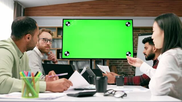 Marketing strategy analysis, stock market trading or corporate teamwork. A team of startups is sitting at a table and talking remotely on a webcam. Green screen. Remote communication, conference.
