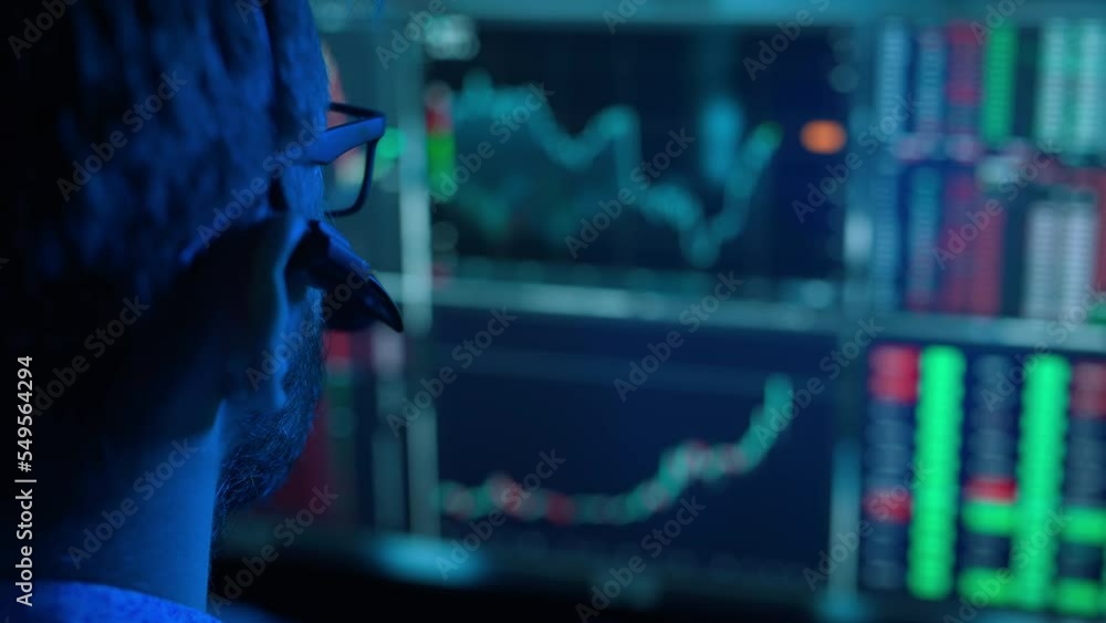 Poster trader is working with multiple computer screens with charts and data analysis and stock broker trad