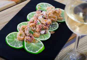 Fried calamari with sepia in batter of tempera flour served with sesame, cushion of pickled limes...