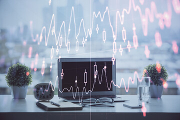 Forex graph hologram on table with computer background. Multi exposure. Concept of financial...