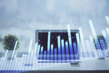 Forex graph hologram on table with computer background. Multi exposure. Concept of financial markets.