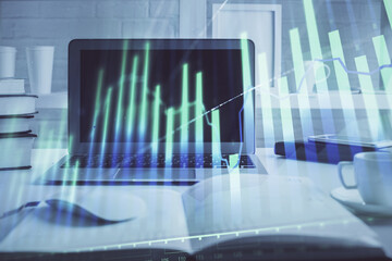 Forex graph hologram on table with computer background. Multi exposure. Concept of financial markets.