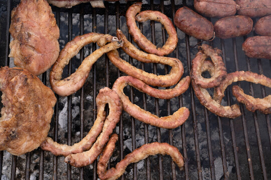 Barbecue outdoor. Top view of chitterlings, beef and pork sausages in the grill. 