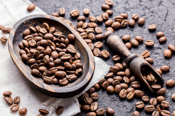 Roasted coffee beans with wooden spoon, closeup image, space for text