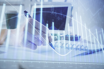 Financial forex graph drawn over hands taking notes background. Concept of research. Multi exposure