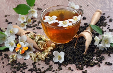 orange butterfly on jasmine flowers. green tea with jasmine on the table. green tea leaves, jasmine...