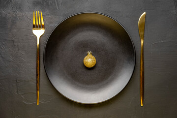 Golden Christmas table. Plate with Christmas decorations on black background. Happy new year.