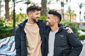 Young couple smiling confident hugging each other at park