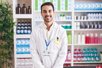 Handsome hispanic man working at pharmacy drugstore with a happy and cool smile on face. lucky...
