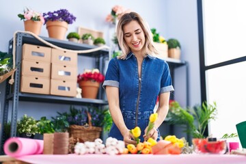 Young woman florist make bouquet of flowers at florist