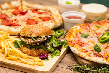 Pizza and hamburger on wooden background
