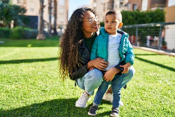 Mother and son hugging each other standing at park